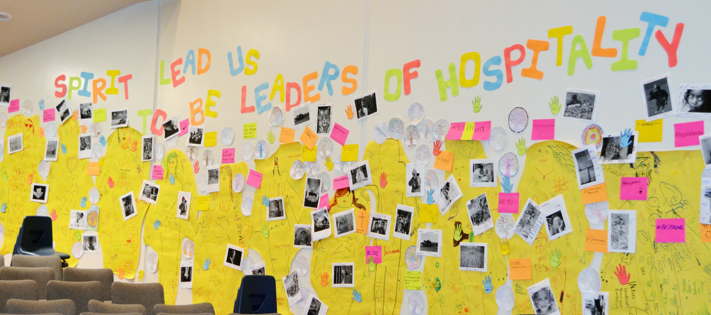 'Spirit lead us to be leaders of hospitality' in letters made of coloured paper, along with decorative art.