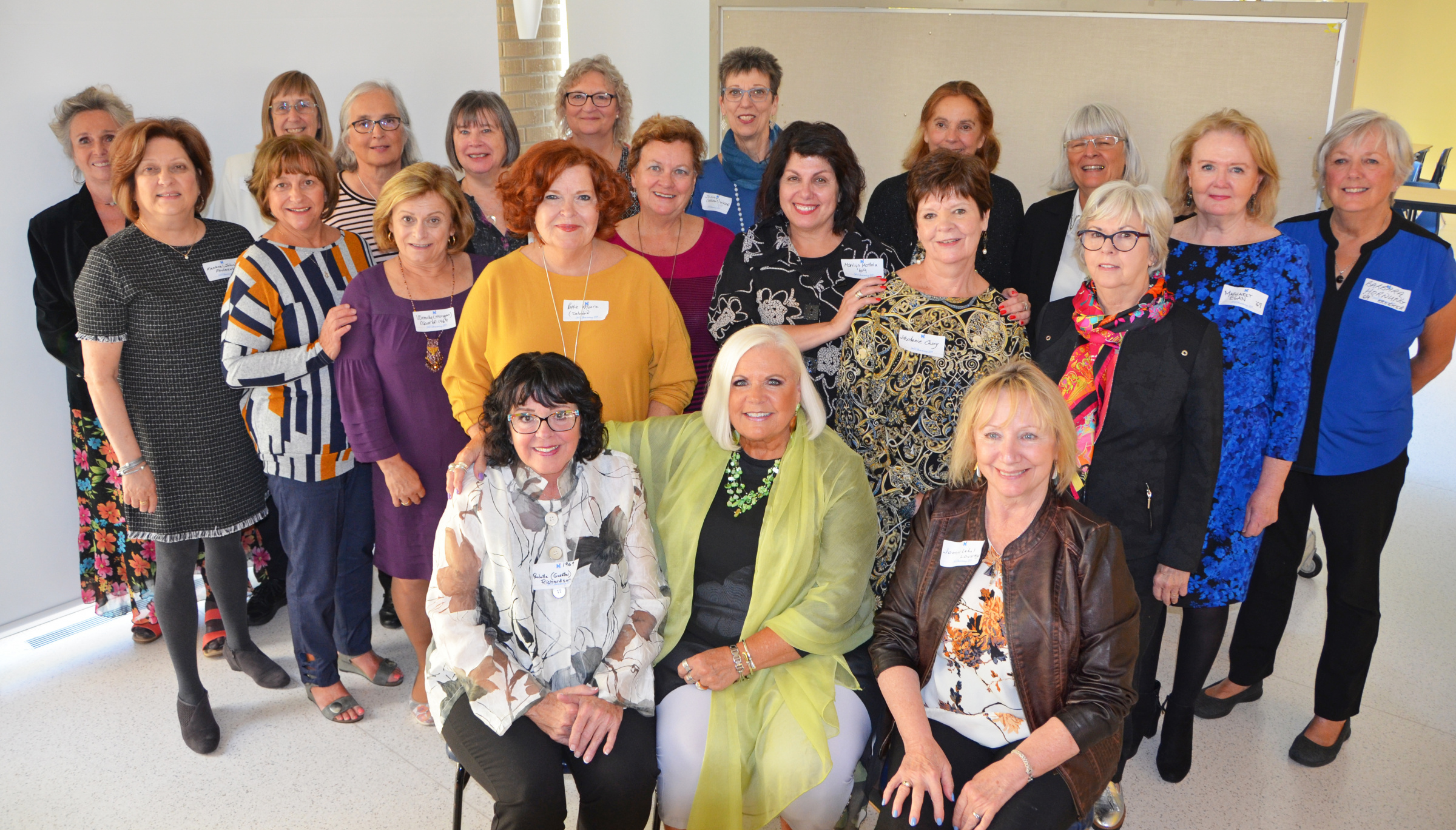 St. Mary's Academy alumnae of varying ages sit and stand close together.