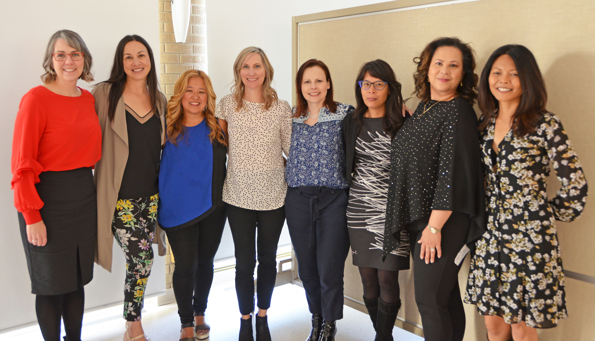 Eight St. Mary's Academy alumnae stand close together.