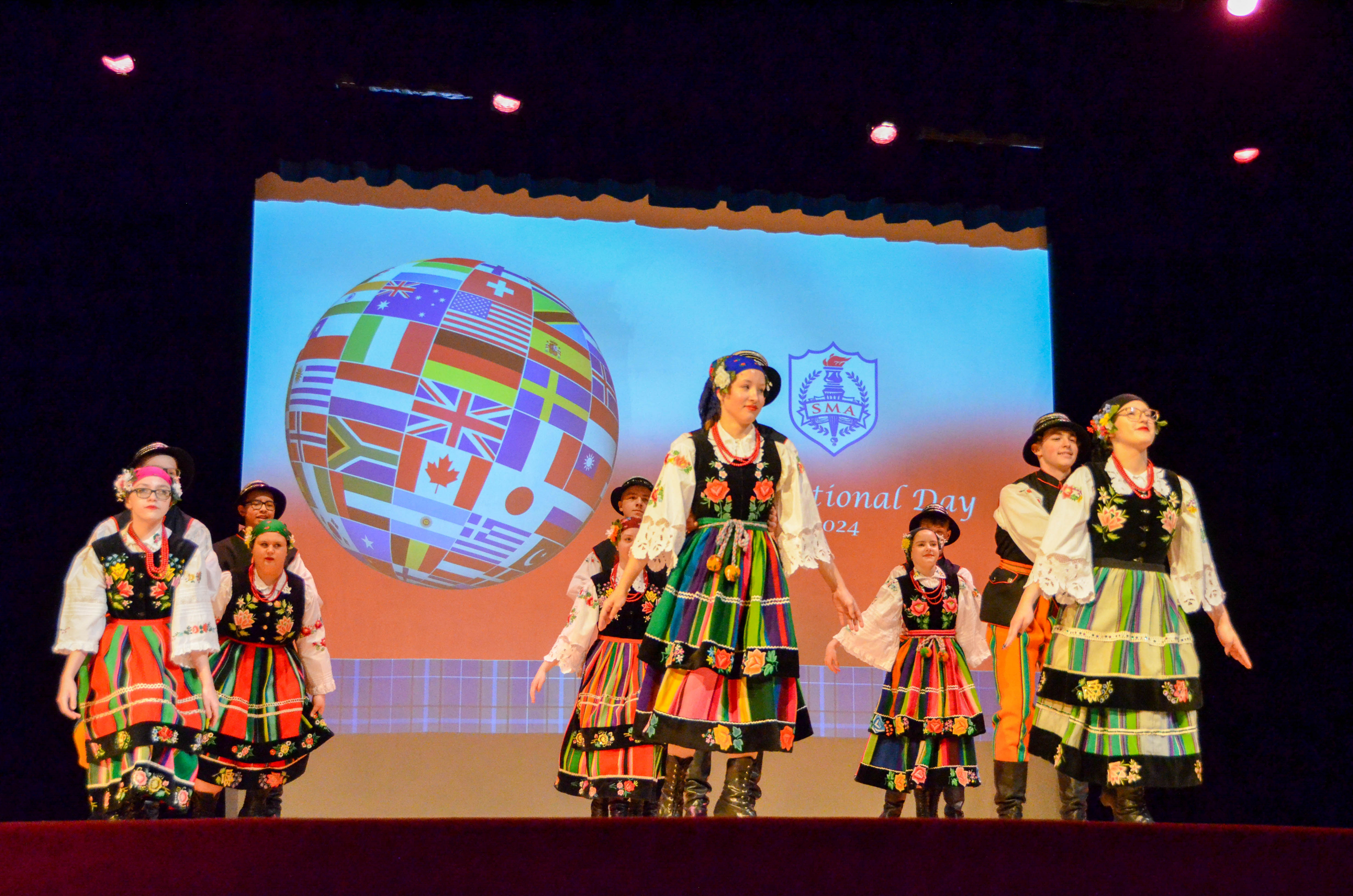 A group of six dancers perform on stage at St. Mary's Academy International Day.