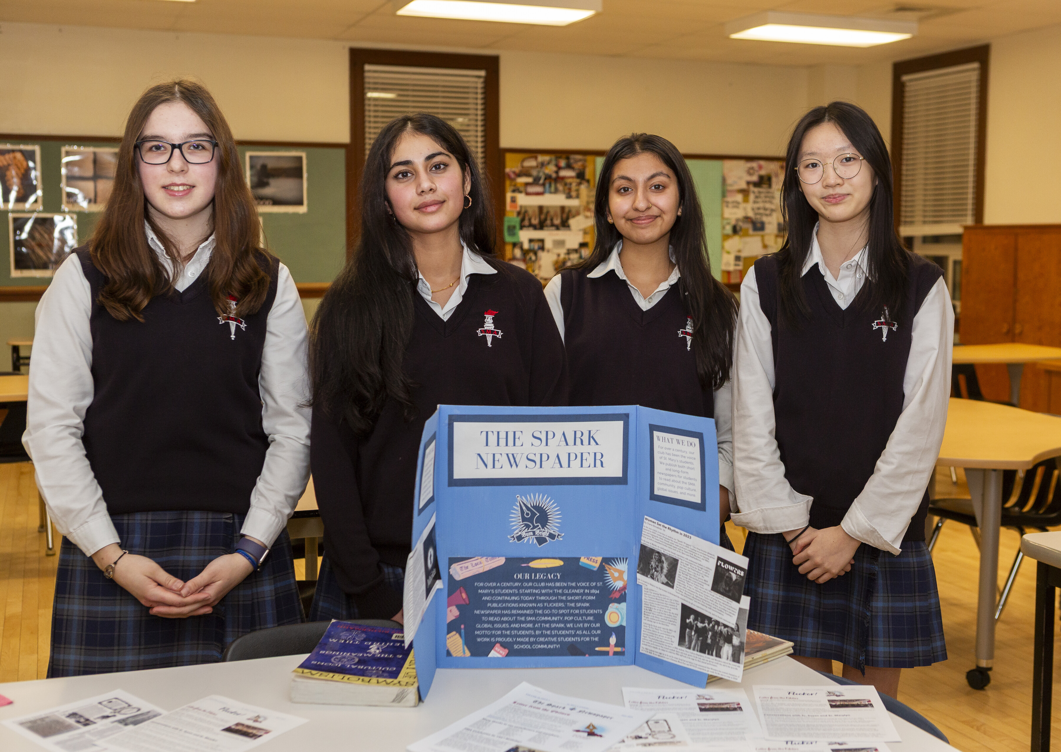 A group of SMA students standing behind a display