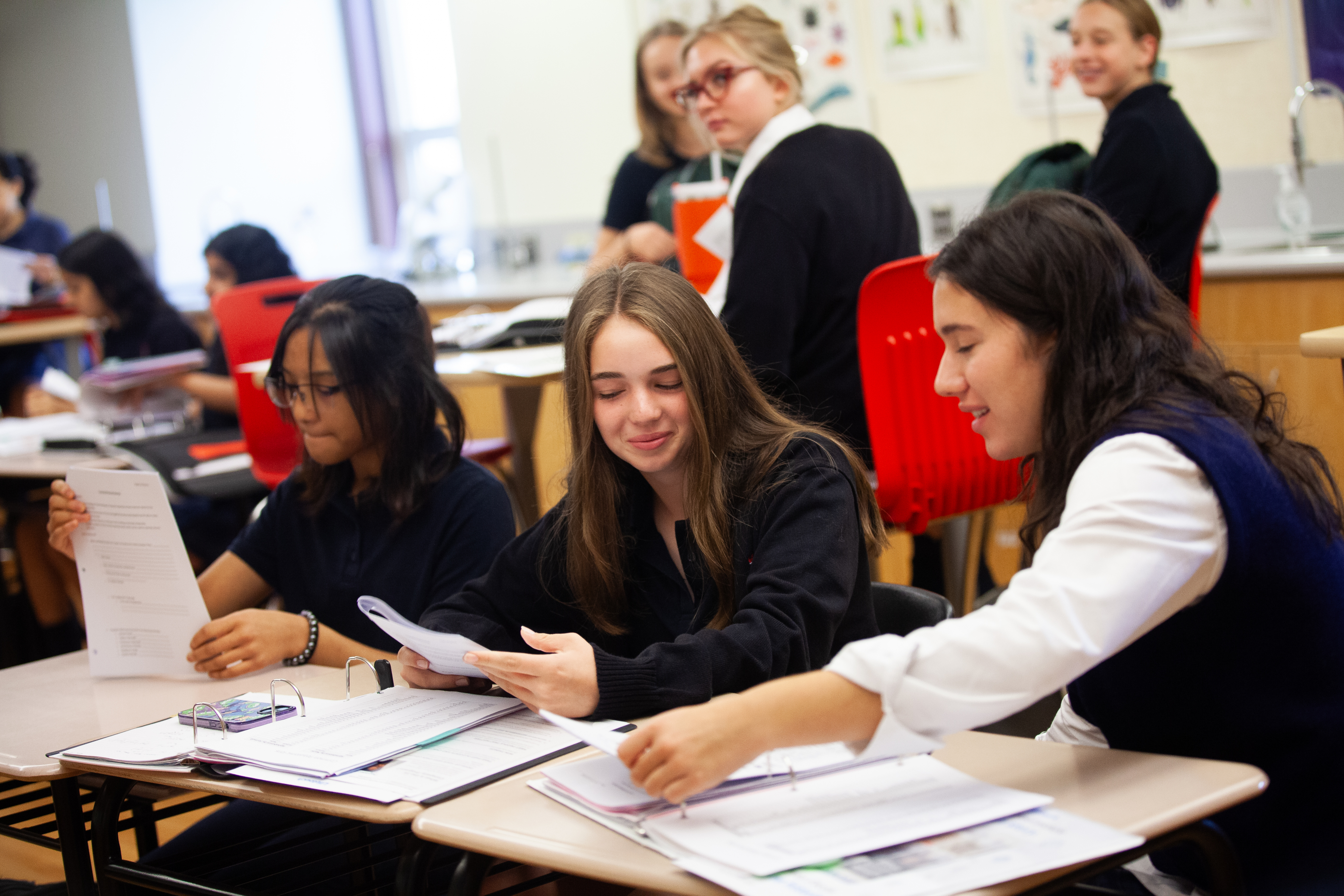 St. Mary's Academy students look at papers in a classroom.