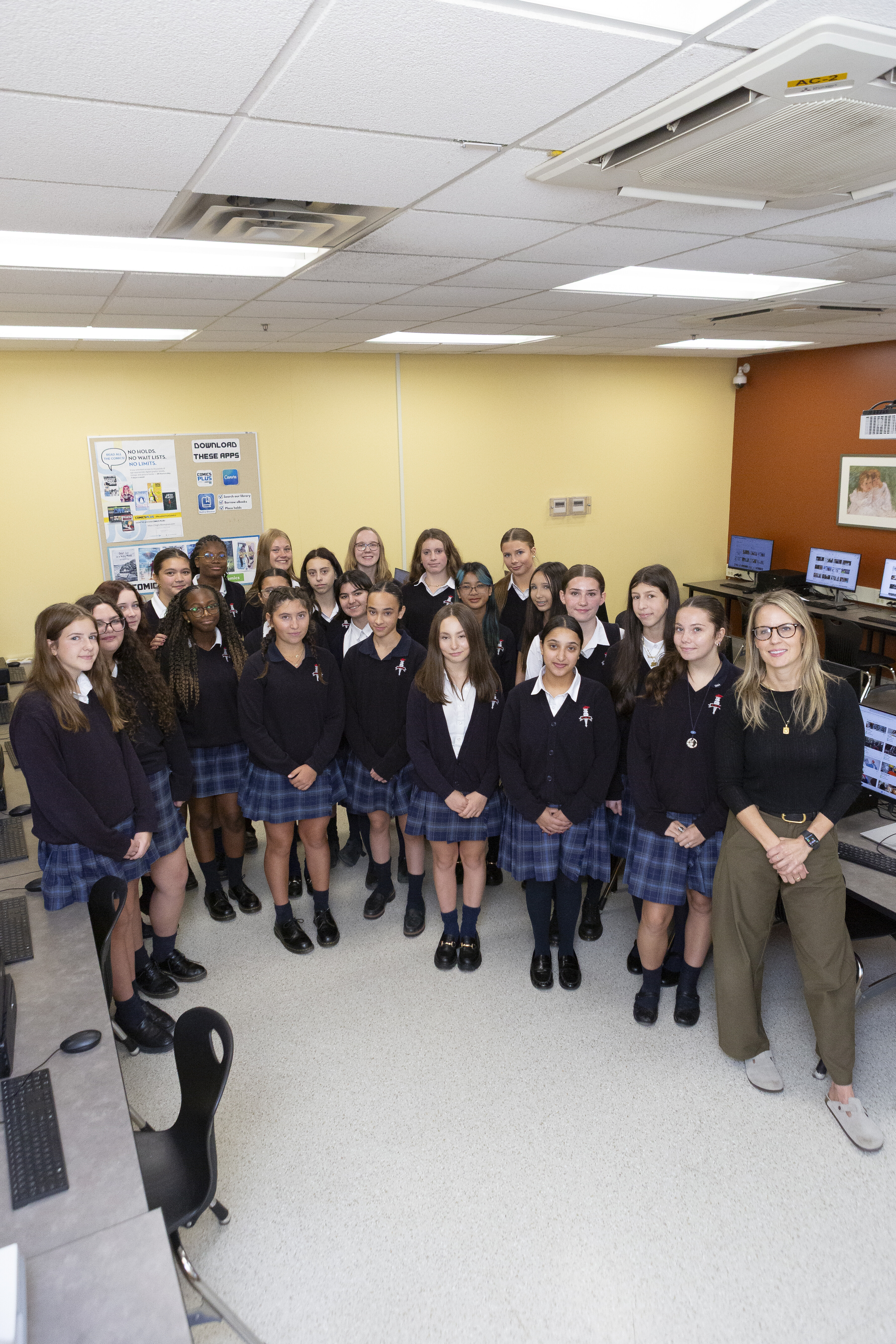 A group of St. Mary's Academy students standing and smiling next to a female teacher.