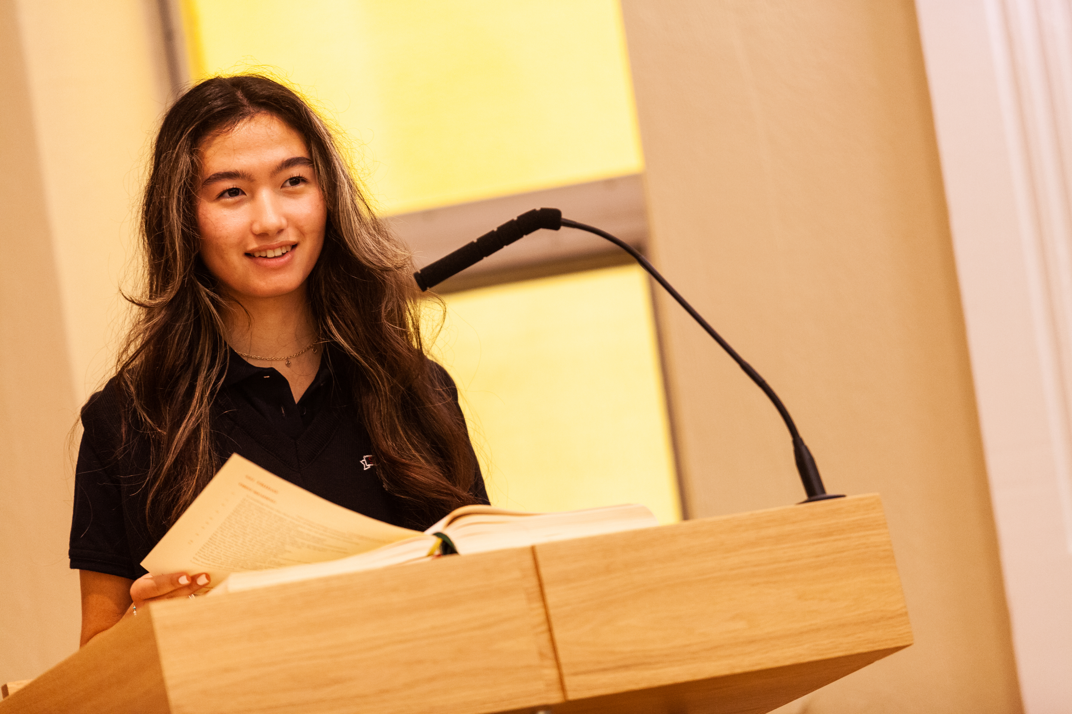 an SMA student holding a Bible on a lectern