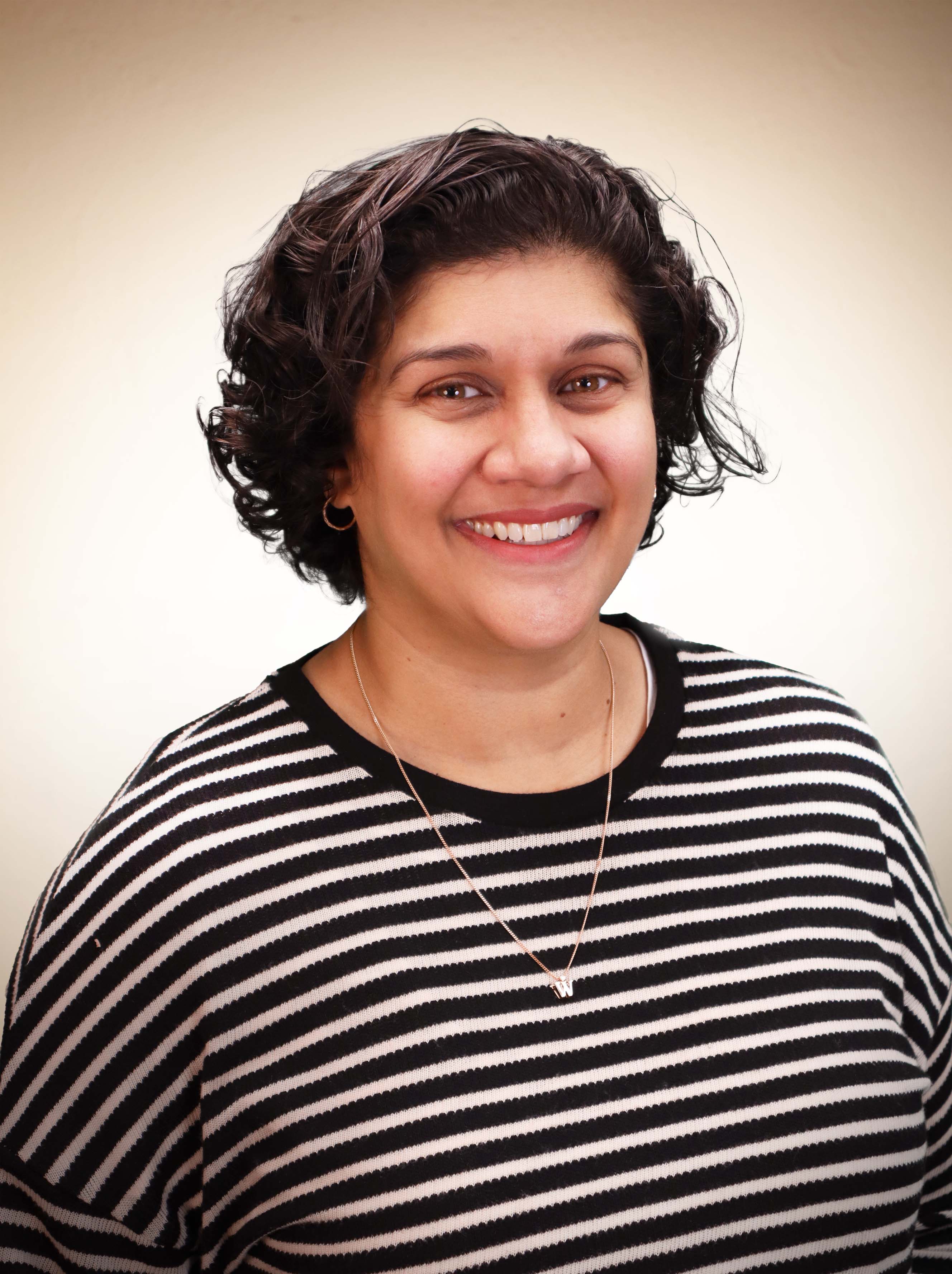 A smiling Sandra Martin, Alumnae Engagement Coordinator at St. Mary's Academy, in a black-and-white-striped shirt.
