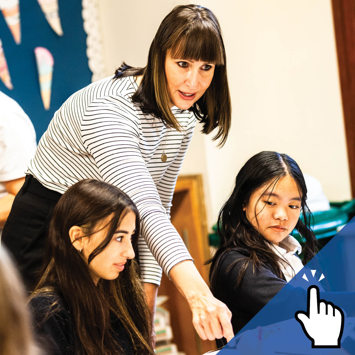 An educator points at something as two students look on.