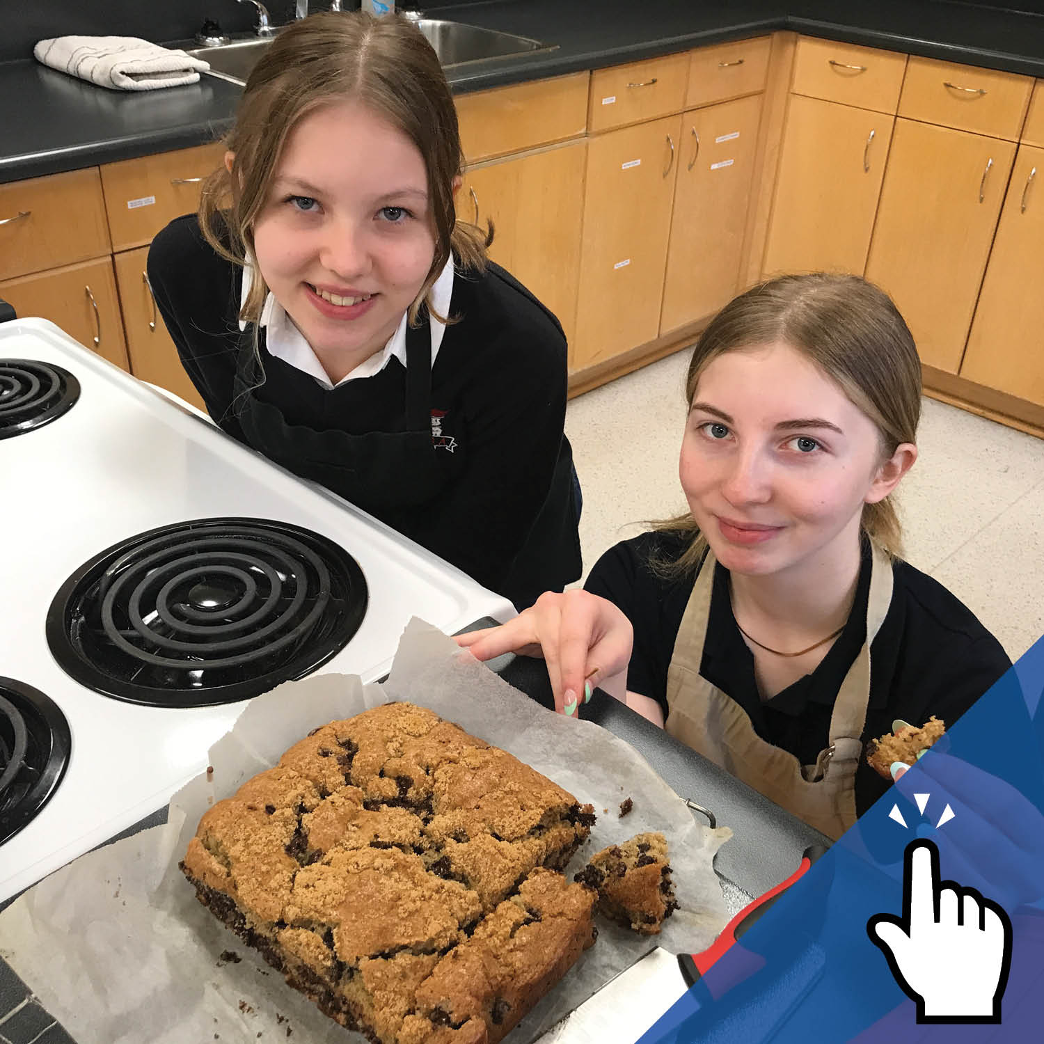 Two St. Mary's Academy students show off their baking in a kitchen.