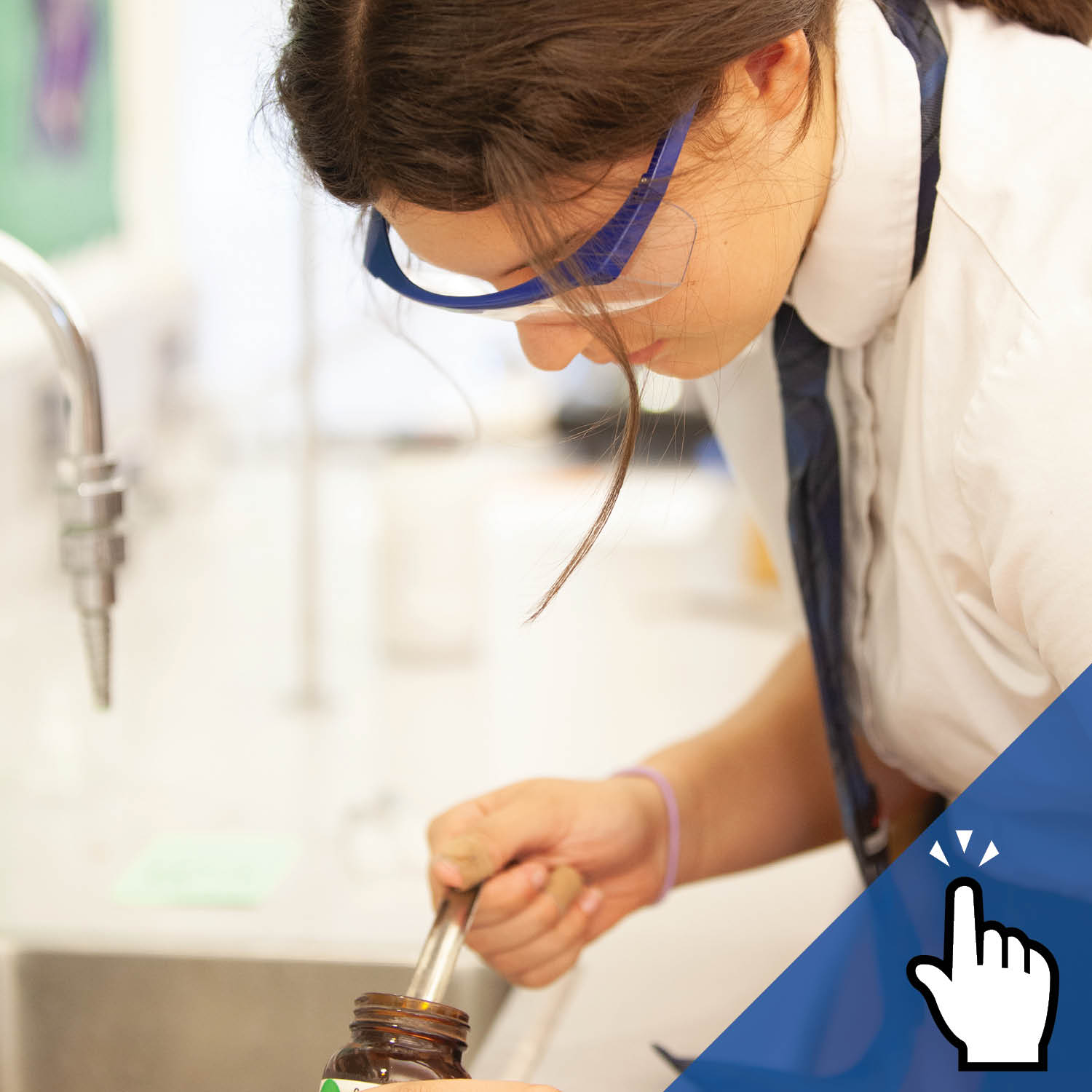 A St. Mary's Academy student wearing goggles extracts a liquid from a bottle.