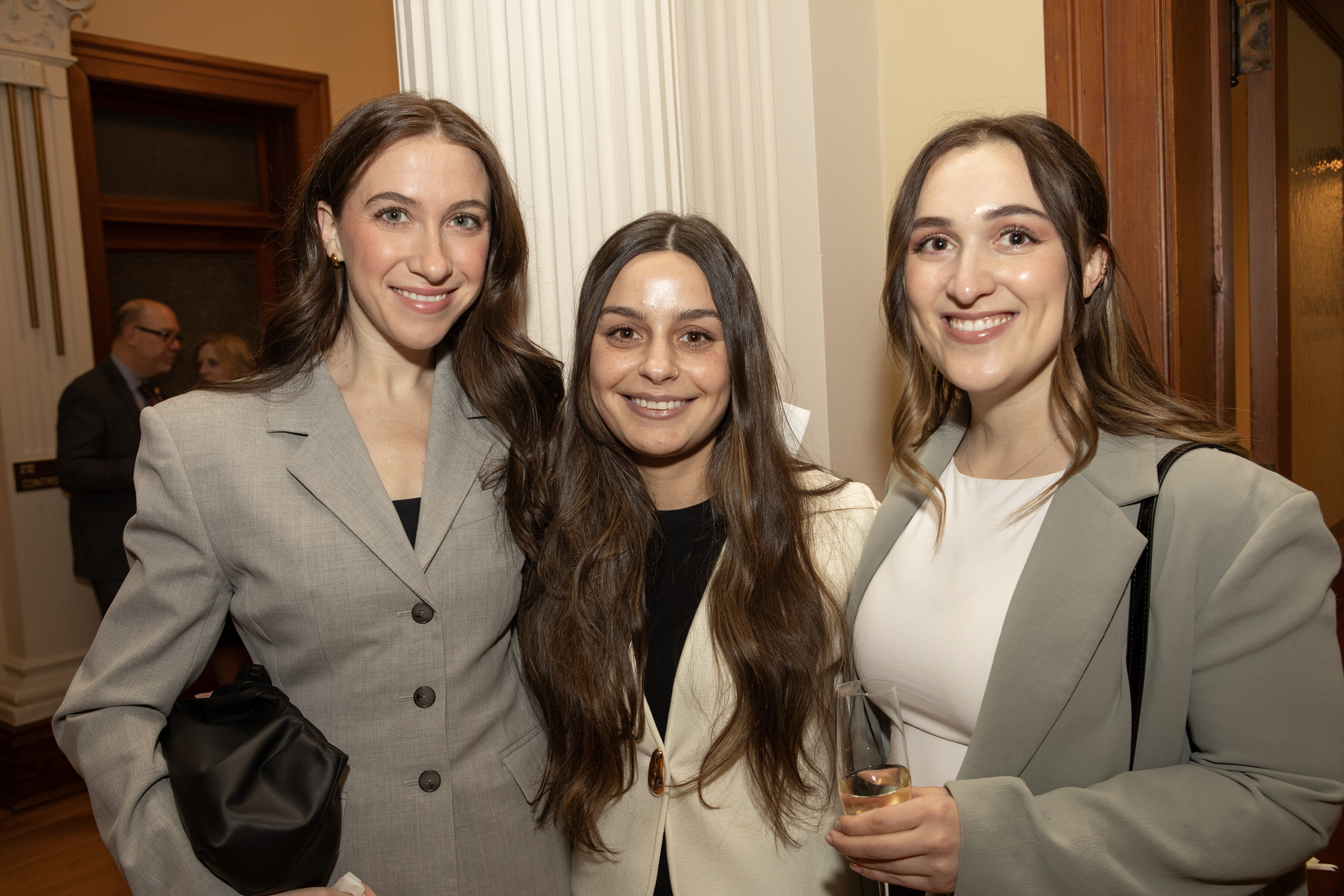 Three women in formal attire standing and posing